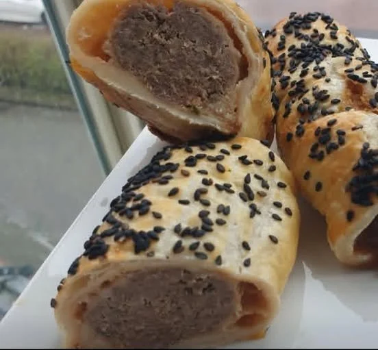 Spicy meat rolls in puff pastry on a serving platter