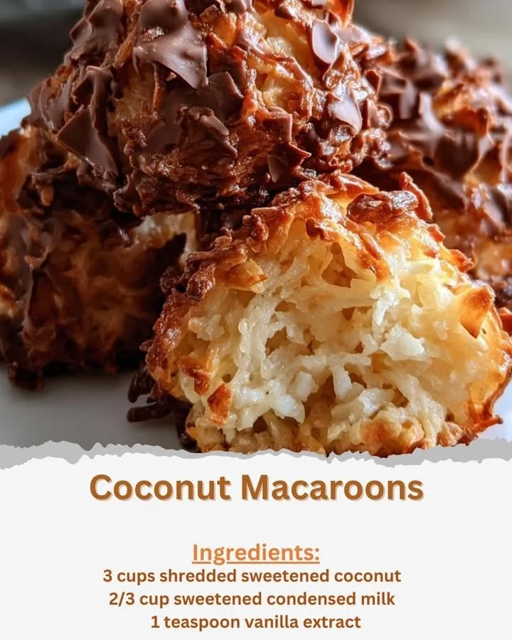 A plate of freshly baked coconut macaroons stacked on a rustic wooden table.