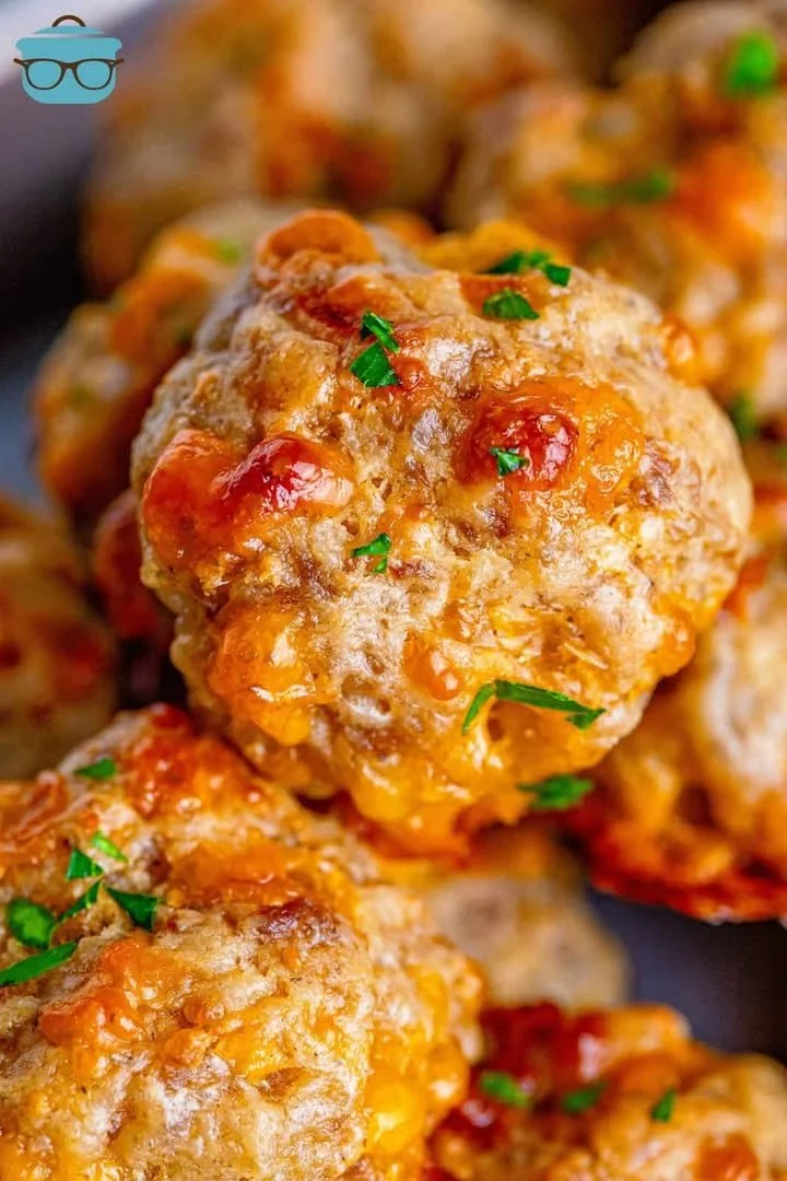 Plate of cream cheese sausage balls garnished with herbs
