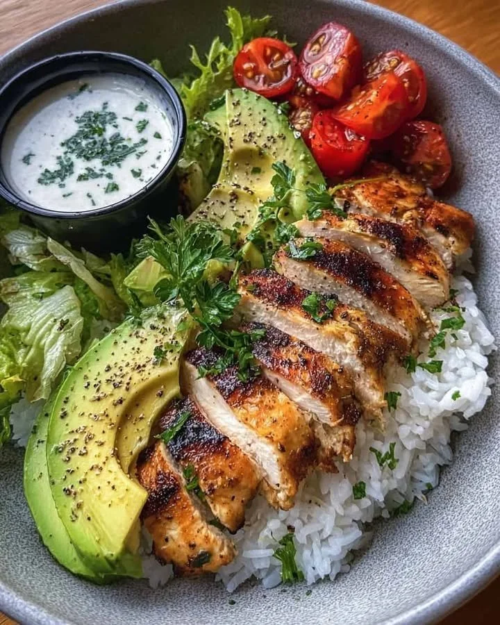 Grilled chicken rice bowl with avocado and creamy herb sauce