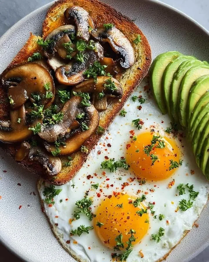 Savory Mushroom Toast with Sunny Eggs & Creamy Avocado Savory mushroom toast topped with sunny-side-up eggs and creamy avocado slice